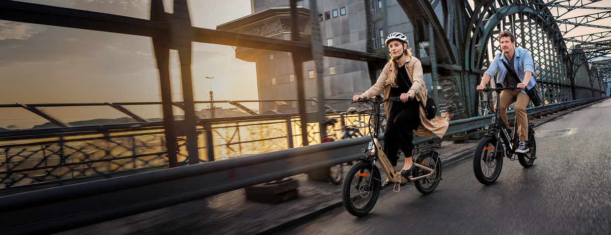 Two riders on ENGWE L20 3.0 Boost electric bikes beside a city bridge